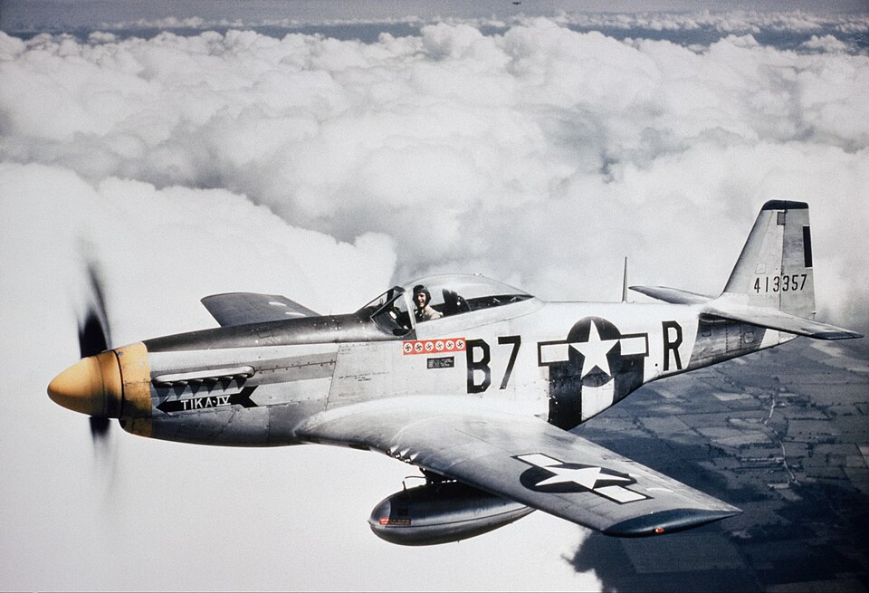 North American P-51 Mustang in flight above clouds, showing the wartime fighter that became North American Aviation's best-known aircraft.