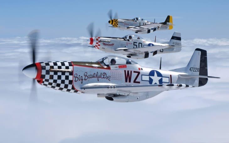 Three P-51 Mustangs flying in formation, led by Big Beautiful Doll WZ-I.