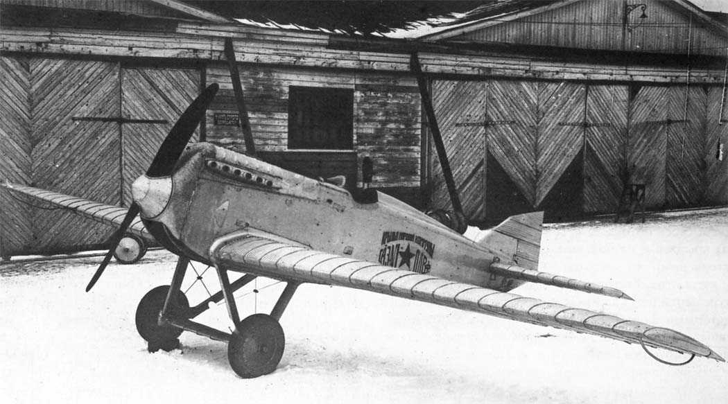 Polikarpov I-1 monoplane fighter parked near hangars