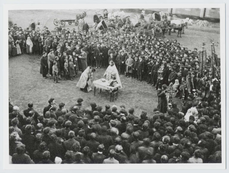 Open-air religious service with visible leadership roles