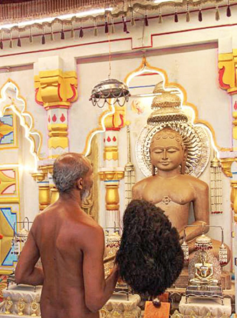 Digambar Jain monk bowing before a Tirthankara image