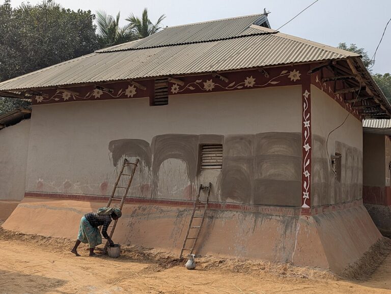 Santal woman at her mud house