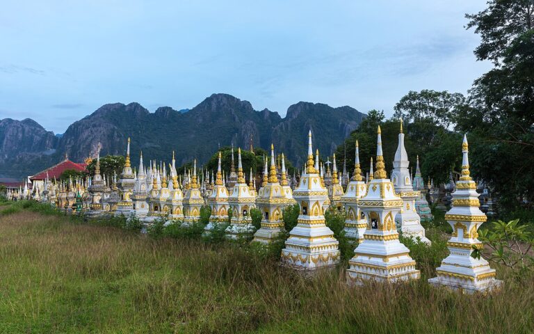 White and golden graves in a Buddhist cemetery at sunrise in Vang Vieng, Laos