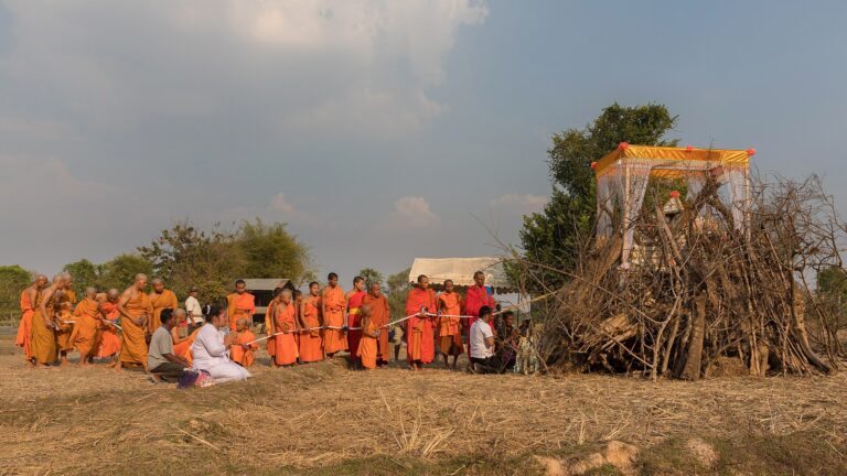 Buddhist monks in procession before a funeral pyre