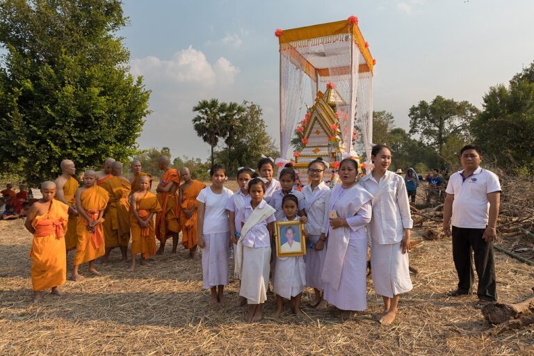 Group of buddhist children in front of a coffin