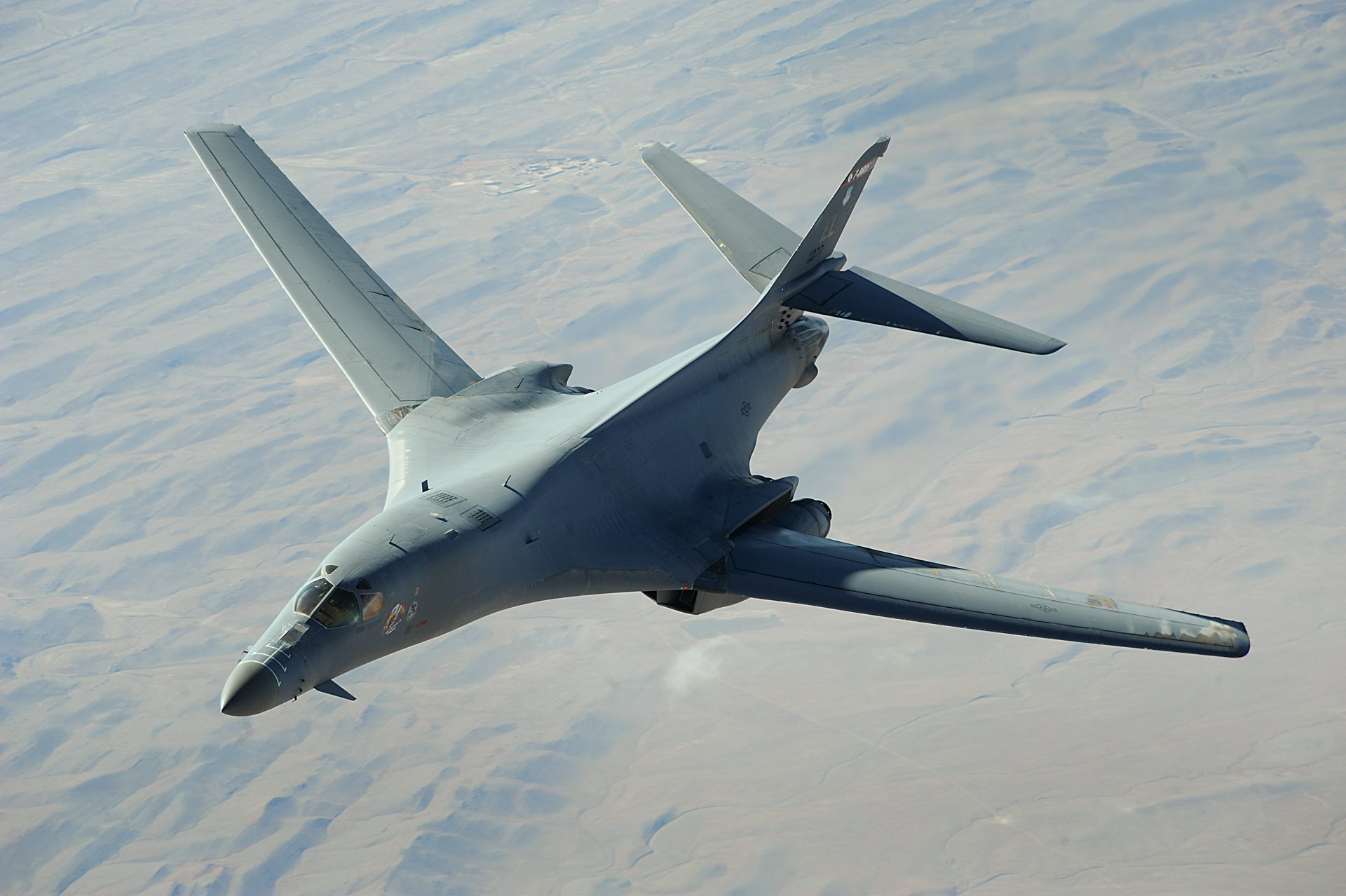 Rockwell B-1 Lancer - A Rockwell B-1 Lancer military bomber aircraft flying over a desert landscape, captured in a high-resolution 4K Ultra HD image. Rockwell ...