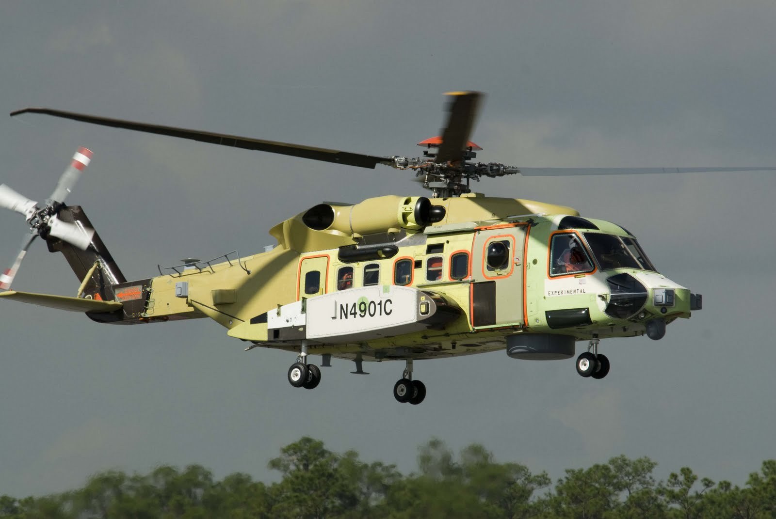 Green CH-148 Cyclone prototype N4901C flying with landing gear down.