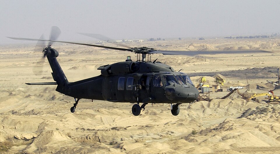 Sikorsky Black Hawk helicopter flying low over desert terrain, showing the utility helicopter family produced by Sikorsky for military service.