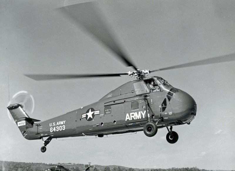U.S. Army Sikorsky H-34 Choctaw number 64303 flying with landing gear extended.