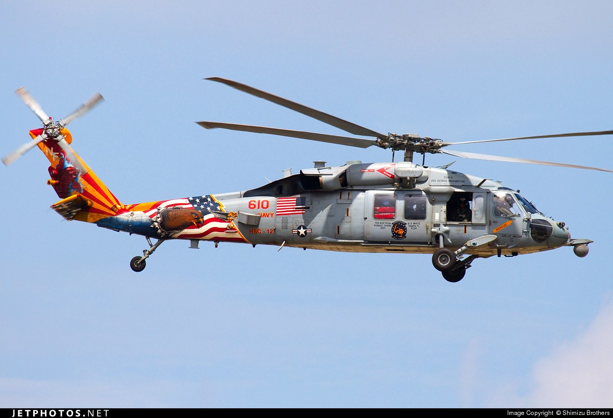 U.S. Navy MH-60S Knighthawk number 610 flying with a flag-painted tail.