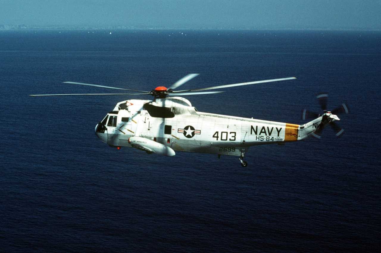 U.S. Navy Sikorsky SH-3 Sea King number 403 flying over the ocean.