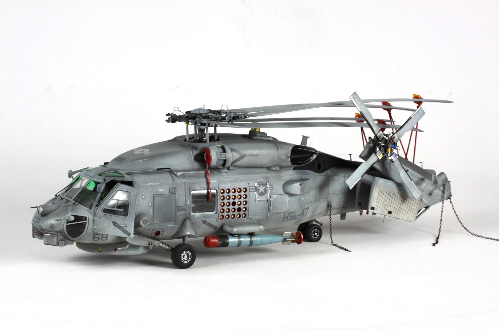 Scale model of a gray Sikorsky SH-60 Seahawk with folded tail and rotor blades.