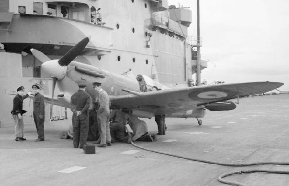 Supermarine Seafire serviced beside a carrier island.
