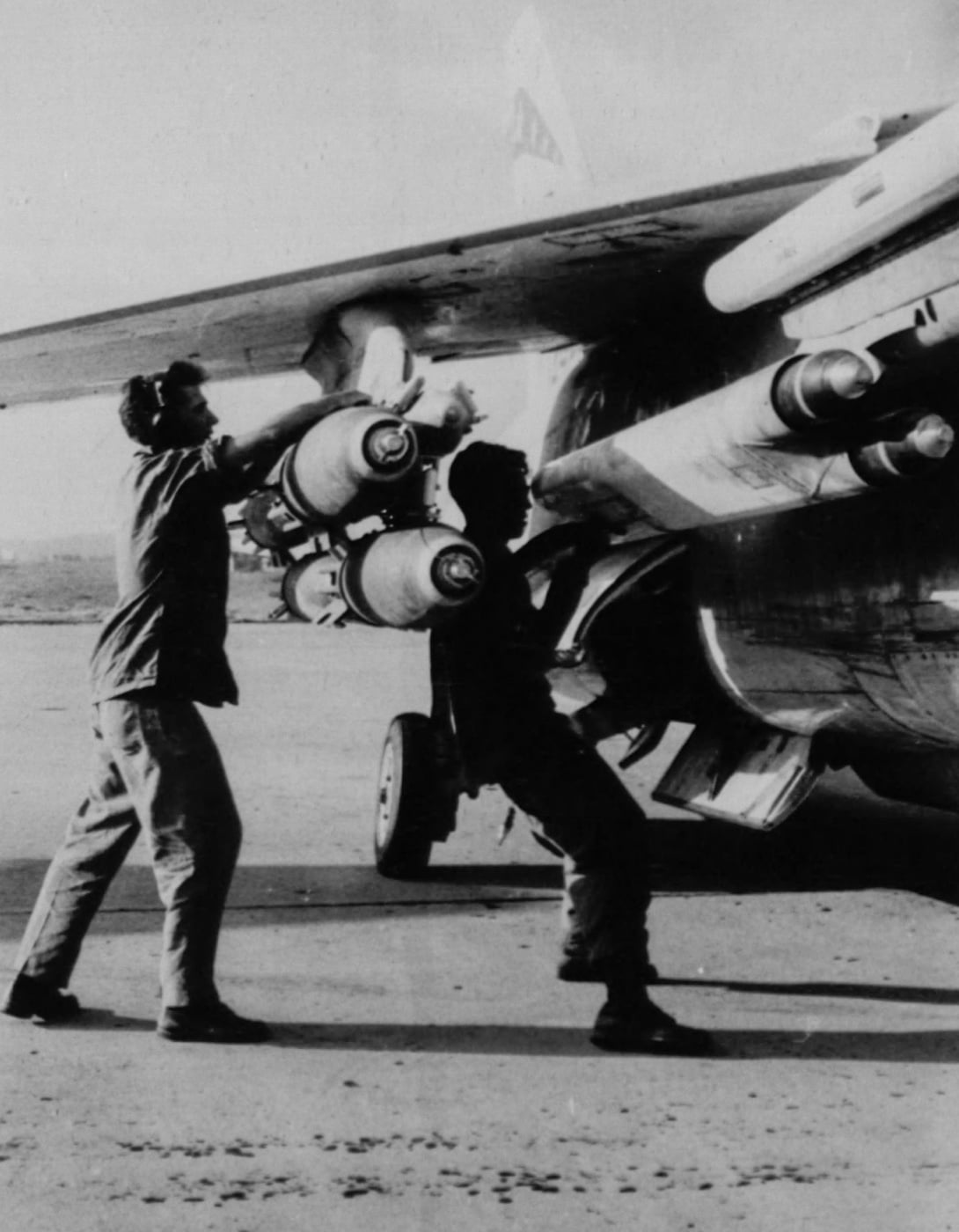 Vought F-8 Crusader - In this photo, Marines load bombs and missiles onto a Crusader during the Vietnam War. Although the plane was the first supersonic jet fi...